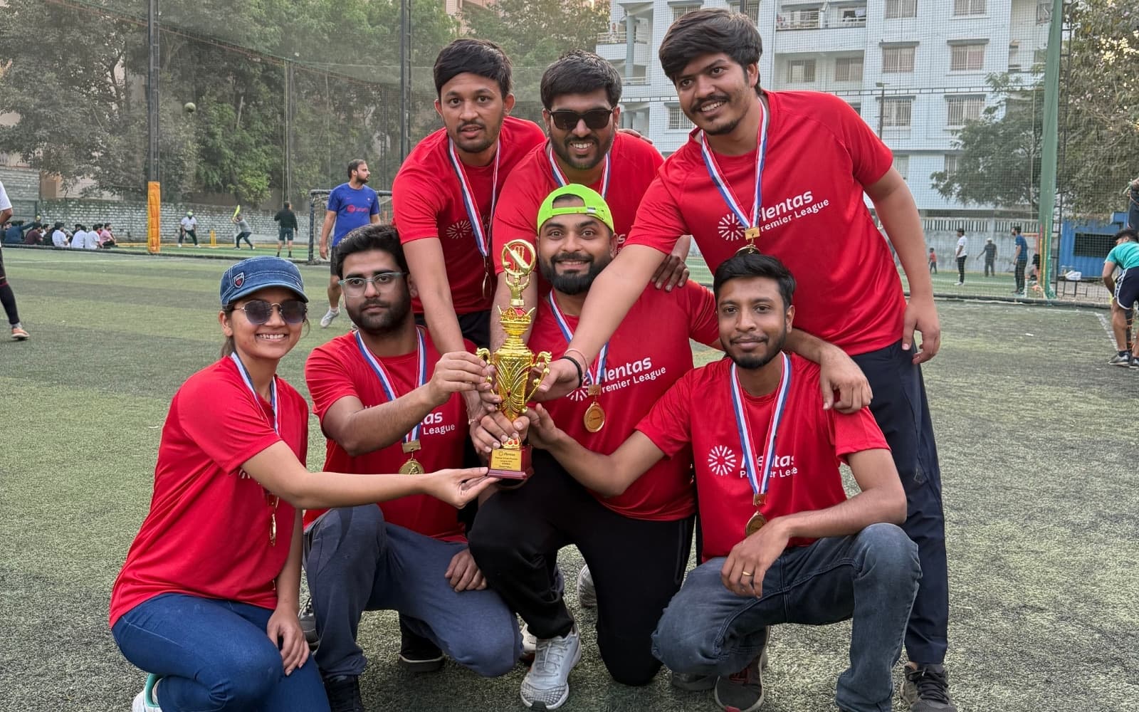 The winning Flentas Premier League team in red jerseys holding the trophy